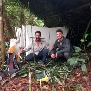 Tres personas interactúan con una serpiente durante una actividad nocturna en la Reserva Nacional Pacaya Samiria, rodeados de vegetación selvática.