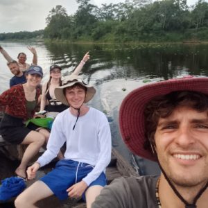 Grupo de personas navegando en bote por un río dentro de la Reserva Nacional Pacaya Samiria, rodeados de selva tropical y disfrutando del recorrido.