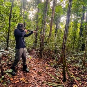 Traveler learning traditional blowgun hunting techniques during a 10-day Matsés Expedition in the Peruvian Amazon rainforest.